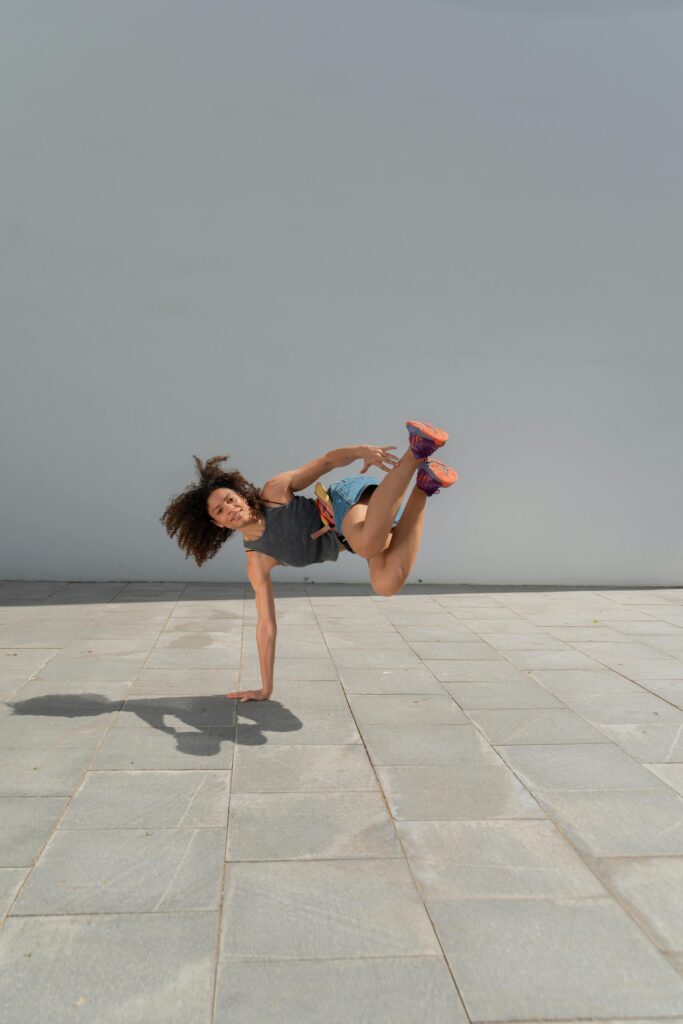 A talented breakdancer executing a move on an outdoor pavement.